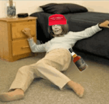 a woman wearing a make liberals cry again hat is laying on the floor next to a bottle of whiskey