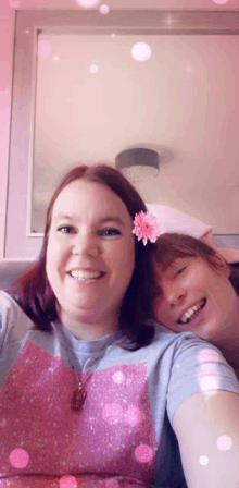 a woman with a flower in her hair is smiling next to another woman