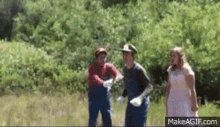 a man dressed as mario and a woman dressed as princess peach are standing next to each other in a field .