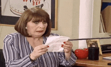 a woman is holding a piece of paper with beef on it