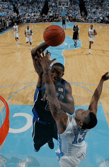 a basketball player with the number 13 on his jersey tries to block another player