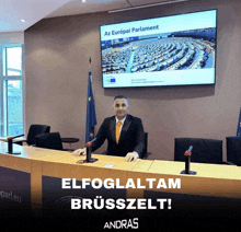 a man sitting at a table in front of a screen that says az europai parlament