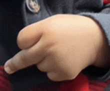 a close up of a child 's hand pointing at something with his finger .