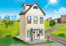 a toy house with a blue door and a woman standing outside