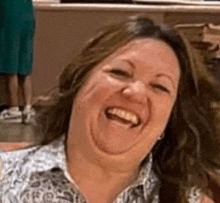 a woman is making a funny face while laughing and smiling .