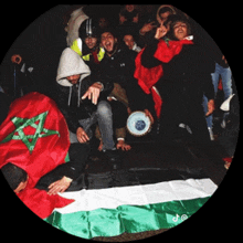 a group of people gathered around a flag with a green star