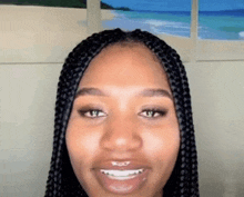 a close up of a woman 's face with braids and braces smiling .