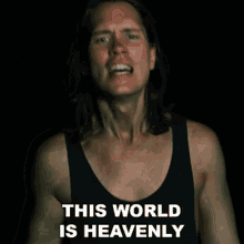 a man in a black tank top with the words this world is heavenly