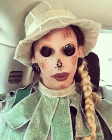 a woman in a scarecrow costume with buttons on her face