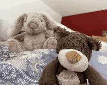 two stuffed animals are laying on a bed including a bear and a rabbit