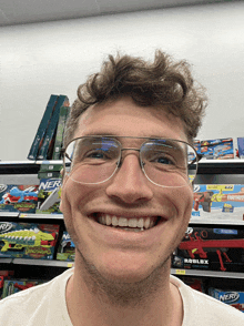 a man wearing glasses is smiling in front of nerf toys