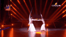 a man and a woman are dancing on a stage with a colors hd logo in the corner