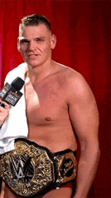 a man without a shirt is wearing a wwe championship belt