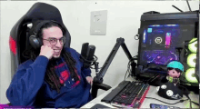 a man with dreadlocks is sitting in a chair in front of a computer and a microphone .