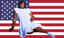 a woman in a white dress and white socks is laying in front of an american flag