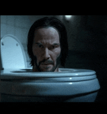 a man with a beard is sticking his head out of a toilet bowl