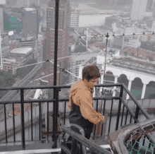 a man is standing on a balcony overlooking a city with a sign that says ' a ' on it