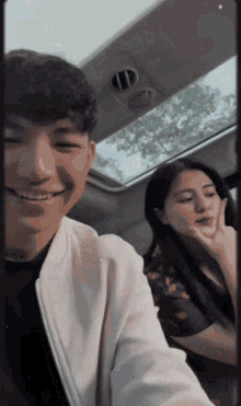 a man and a woman are sitting in a car smiling