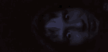 a close up of a person 's face in the dark with their eyes open