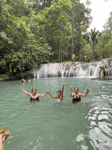 three women are posing for a picture in the water