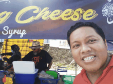 a man stands in front of a cheese syrup stand