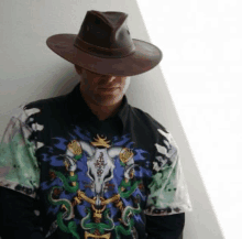 a man wearing a hat and a shirt with a bull skull and snakes on it