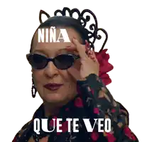 a woman wearing sunglasses has the word niña on her head