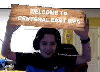 a young boy wearing headphones is holding a sign that says welcome to central east rpc