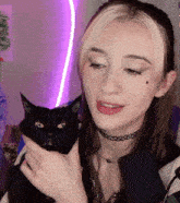 a woman holds a black cat in her arms