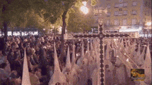 a crowd of people are gathered in front of a large cross and a sign that says ' alianzas ' on it