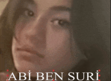 a close up of a woman 's face with the words " abi ben suri " above her