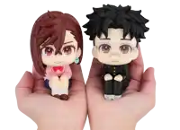 a boy and a girl figurine are being held in a person 's hands