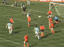 a group of soccer players are playing a game on a field sponsored by lighthouse