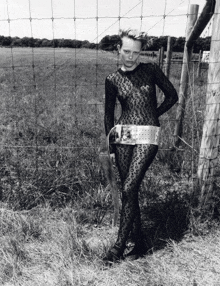 a woman in a leopard print outfit is standing in a field