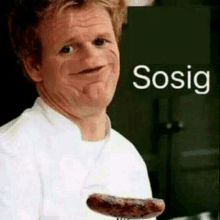 a man in a chef 's uniform is holding a sausage in his hand and making a funny face .