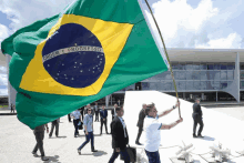 a man is holding a flag that says ordem e progresso on it