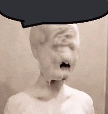 a statue of a man with foam on his face and a speech bubble above his head