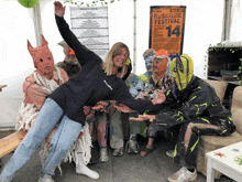 a group of people are posing in front of a ruskilde festival sign