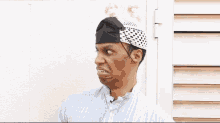 a man wearing a bandana on his head is making a face