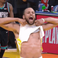 a shirtless basketball player is taking off his shirt on the court .