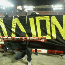 a man holding a scarf in front of a sign that says union