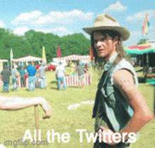 a man in a cowboy hat is standing in a field with the words " all the twitters " written below him