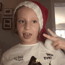 a young girl wearing a santa hat and a 365 days shirt