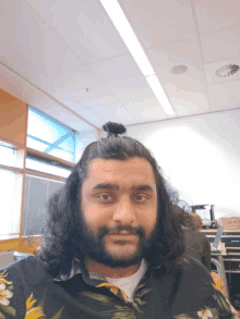 a man with long hair and a beard wearing a shirt with flowers on it