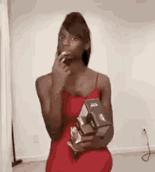 a woman in a red dress is holding a box of cereal and a cigarette in her mouth .