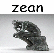 a statue of a man sitting on a rock with the word zean above him