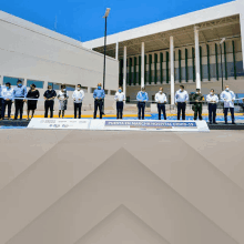 a group of people standing in front of a building with a sign that says puesta en marcha hospital covid-19