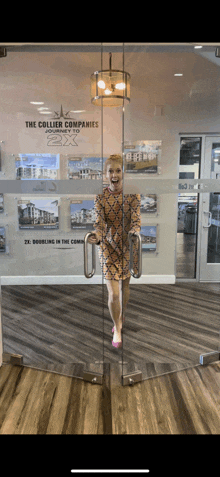 a woman stands in front of a glass door that says the collier companies on it