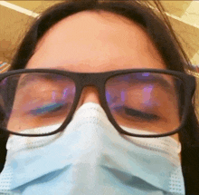 a woman wearing glasses and a face mask with her eyes closed