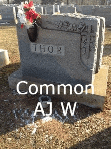 a gravestone with the name thor and a vase of flowers on it